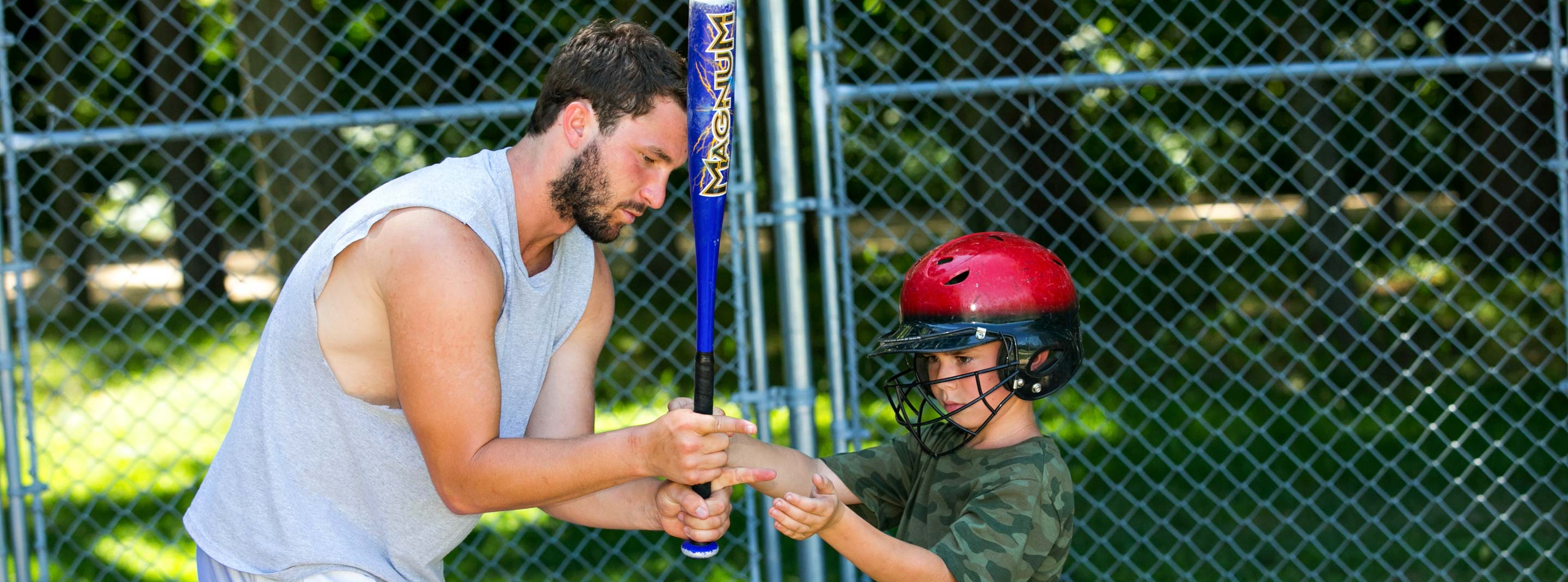 Staff helping camper with baseball