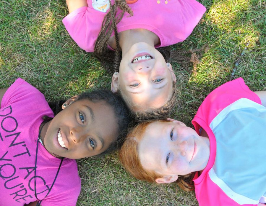 Three girls laying on grass